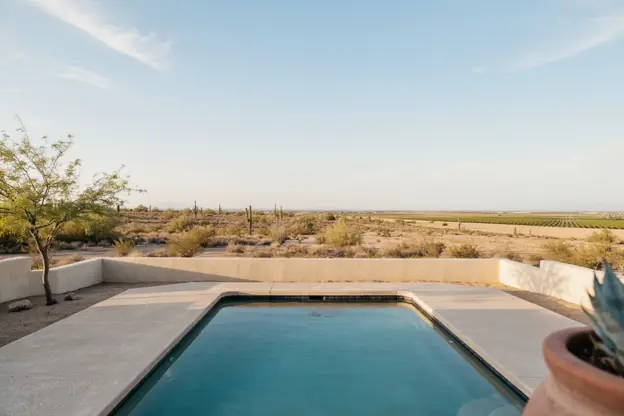 Rectangular pool with a cool-deck surface in a Casa Grande backyard, open desert beyond